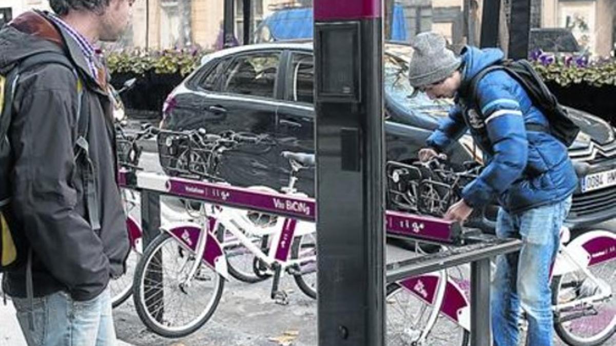 Expectación 8 Un usuario del Bicing eléctrico coge su bici, el martes, ante la mirada de un curioso.