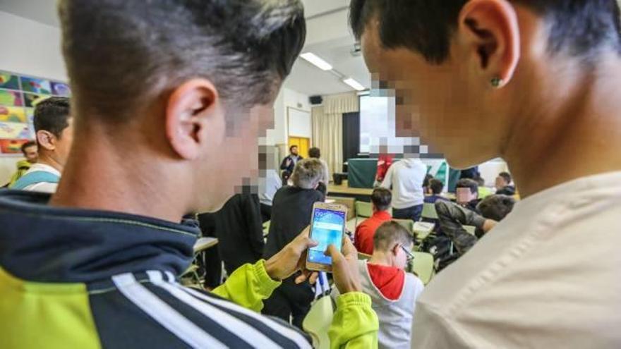 Dos estudiantes miran el móvil en uno de los institutos de Almoradí.