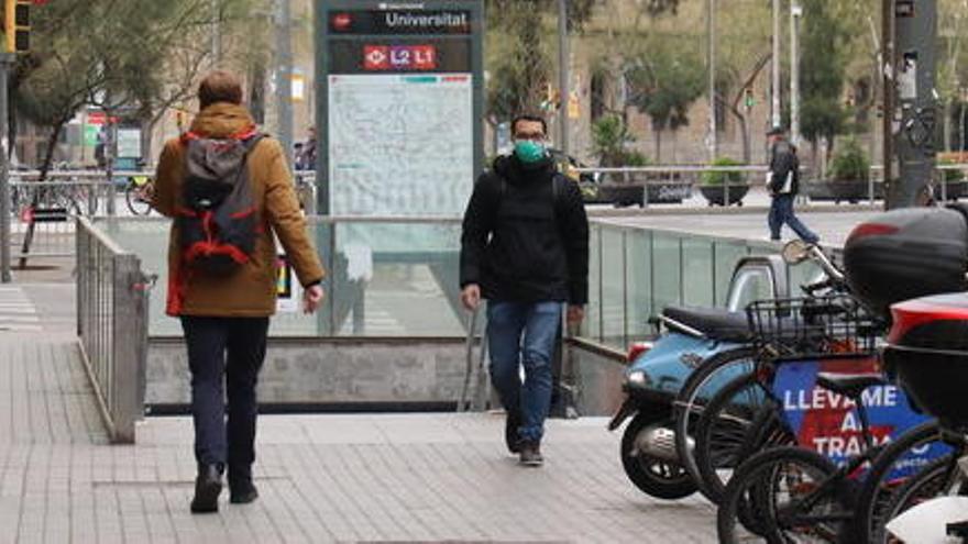 Una persona sortint del Metro amb màscara