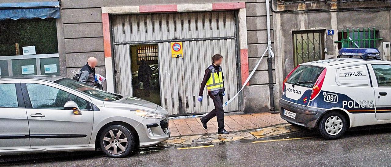 Agentes en la cochera en la que se produjeron los hechos, durante la investigación.