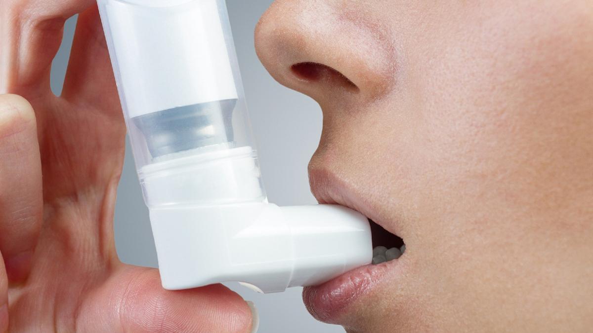 Un joven utilizando un inhalador.