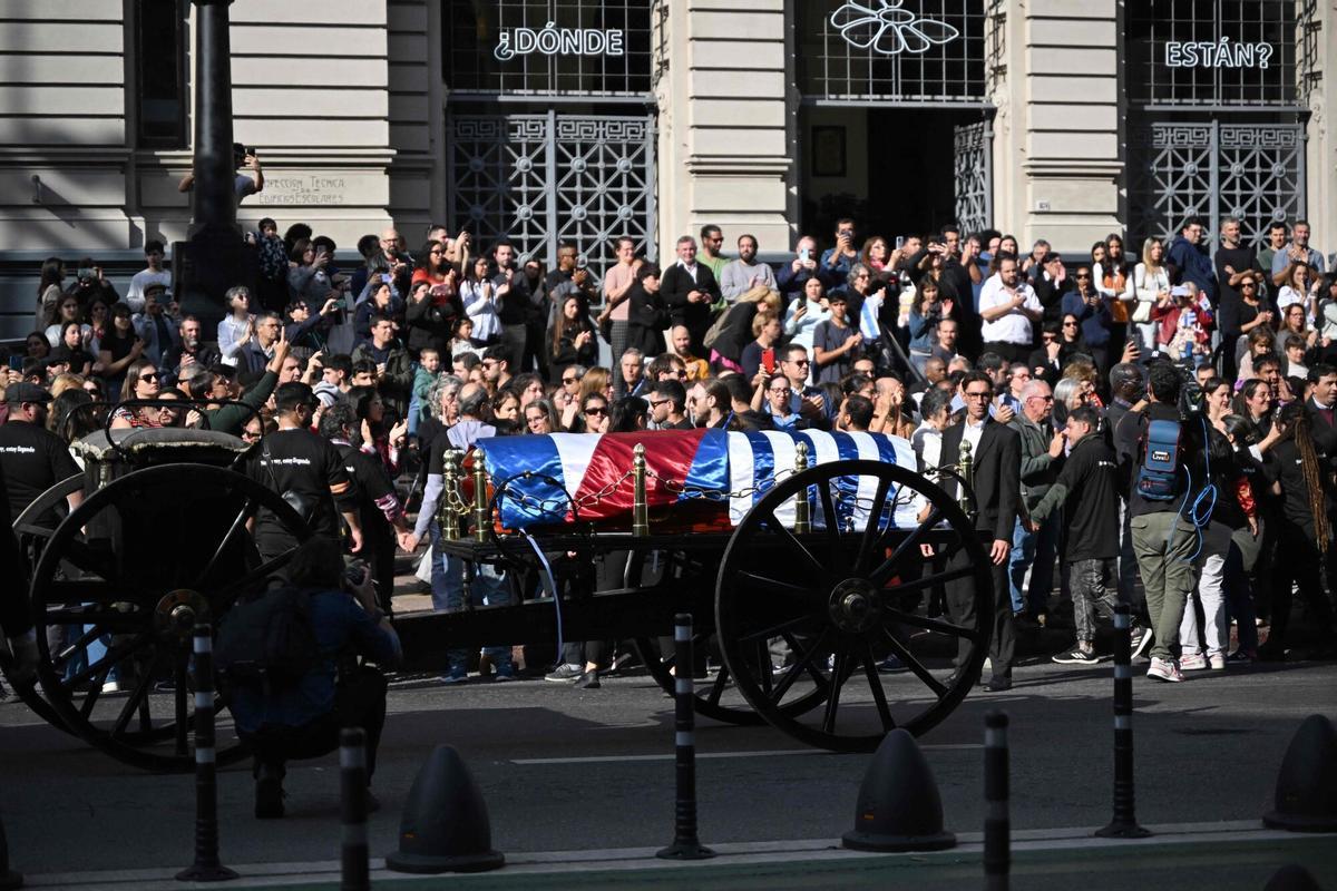 The funeral cortege of Uruguays former President Jose Pepe Mujica makes its way in downtown Montevideo, on May 14, 2025, a day after his death. Mujica, an ex-guerrilla fighter and hero of the Latin American left, died on May 13, 2025 at the age of 89. The humble leader -- who once spent a dozen years behind bars for revolutionary activity -- lost his battle against cancer after announcing in January the disease had spread and he would stop treatment. (Photo by Eitan ABRAMOVICH / AFP)