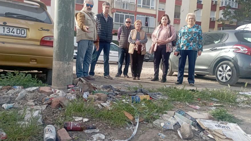 Los vecinos, el pasado lunes junto a basura acumulada en esta parcela, propiedad una parte del Ayuntamiento y el resto de Adif.