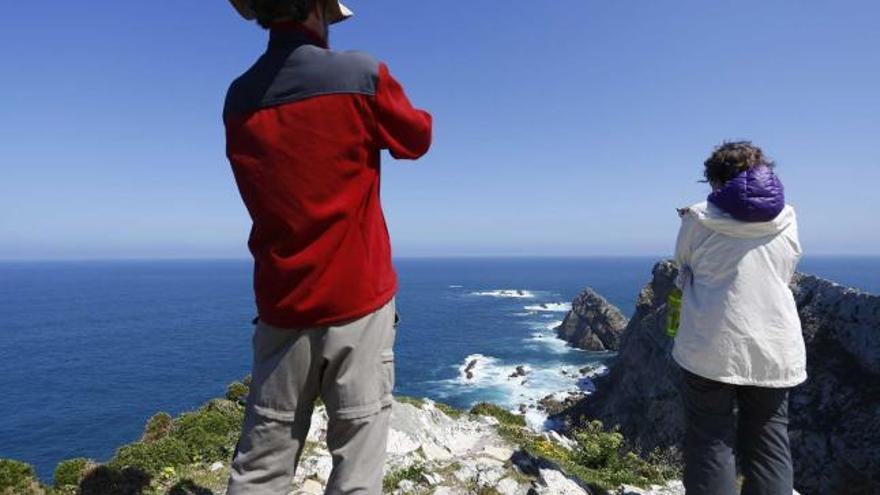 Dos turistas canadienses, admirando el Cabo Peñas la pasada semana.