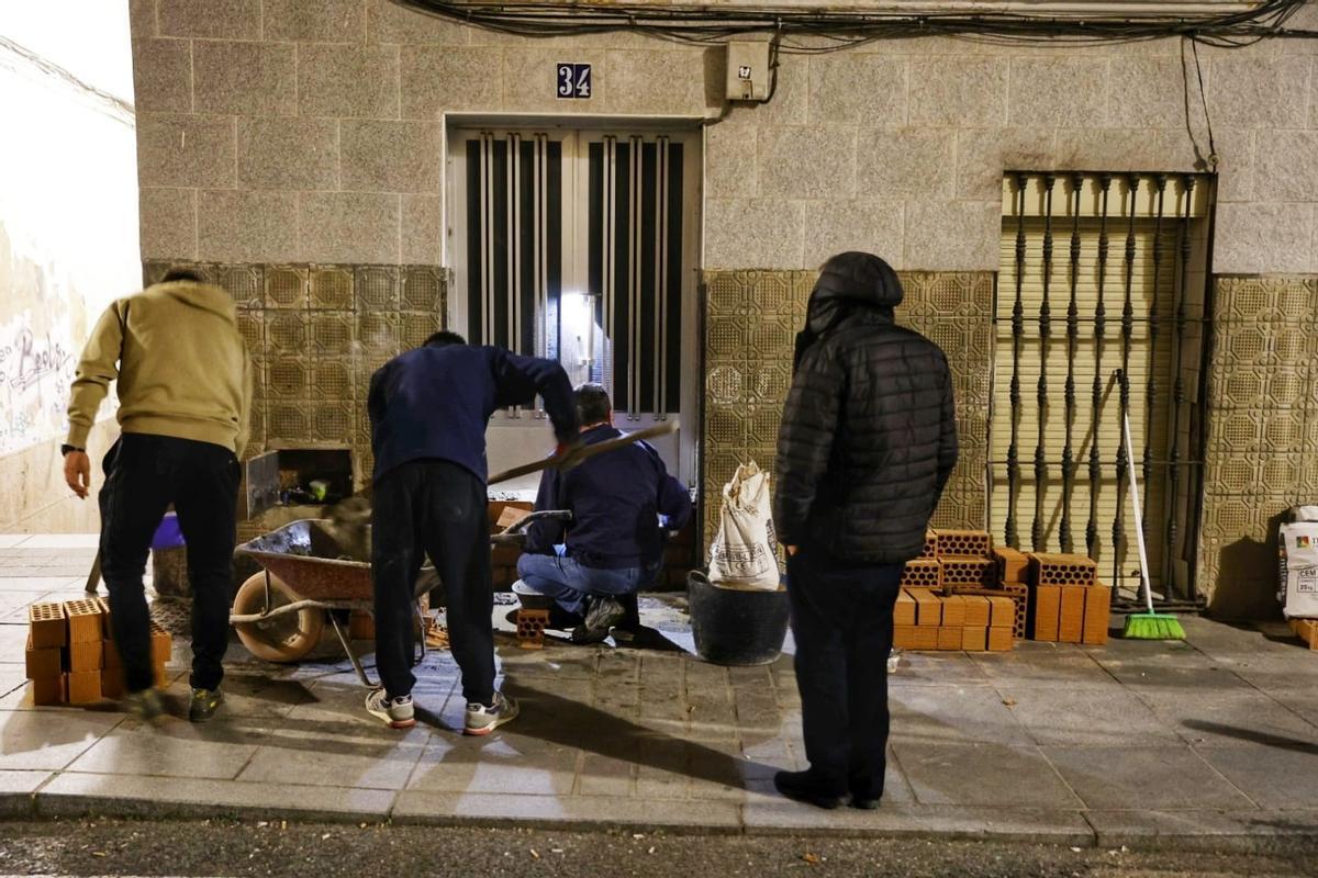 Albañiles del número 34 de Barrionuevo tapian la entrada con ladrillos este lunes.