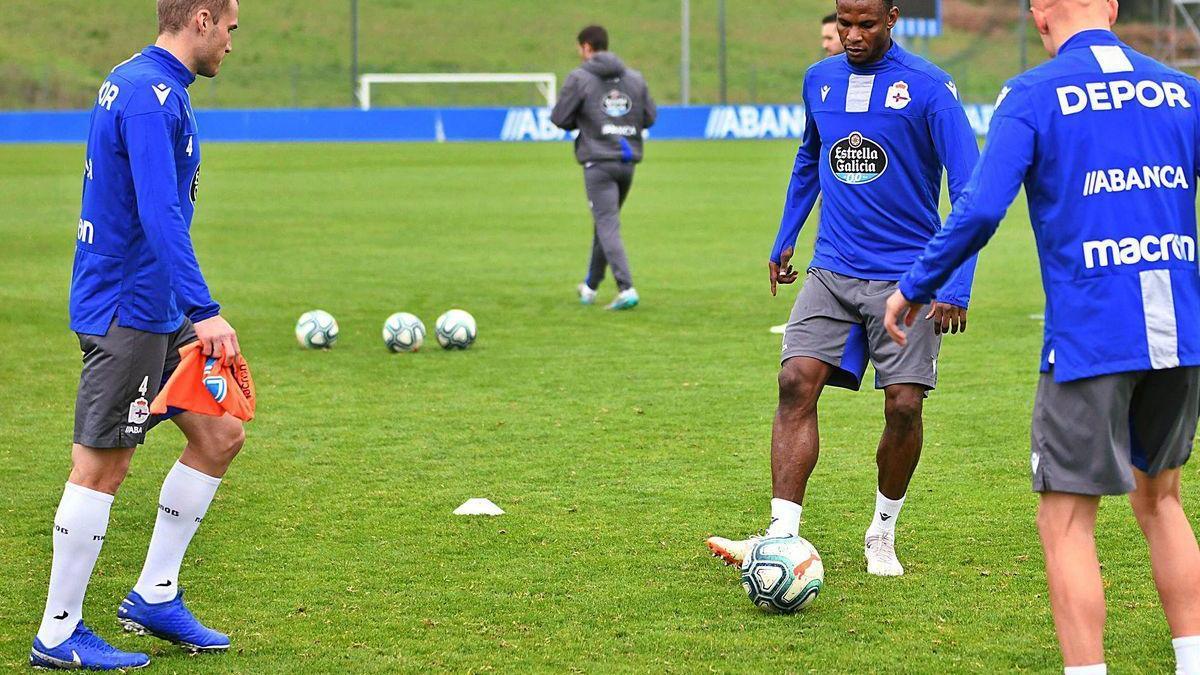 Álex Bergantiños y Uche Agbo pelotean con Víctor Mollejo sobre el césped de Abegondo.