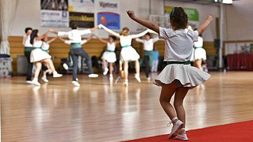 Una joveníssima balladora de la colla manresana Dintre el Bosc seguint els passos dels dansaires més grans