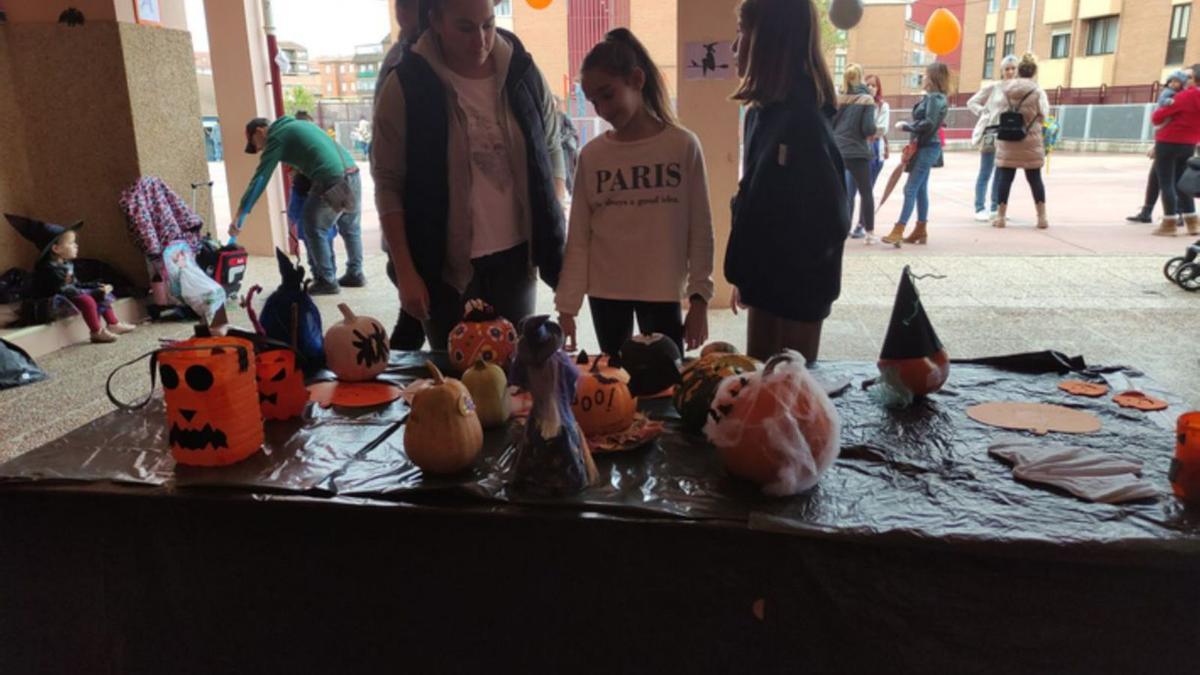 Arriba, calabazas participantes en el concurso del AMPA de Buenos Aires y abajo, preparando las castañas asadas, en el magosto del colegio Virgen de la Vega. E. P.