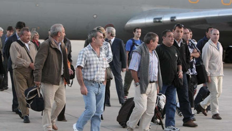 Los trece tripulantes españoles del pesquero Playa de Bakio, secuestrado por piratas en Somalia, a su llegada a la base aérea de Torrejón de Ardoz, en Madrid, donde han sido recibidos por la ministra de Medio Ambiente, Medio Rural y Marino, Elena Espinosa.