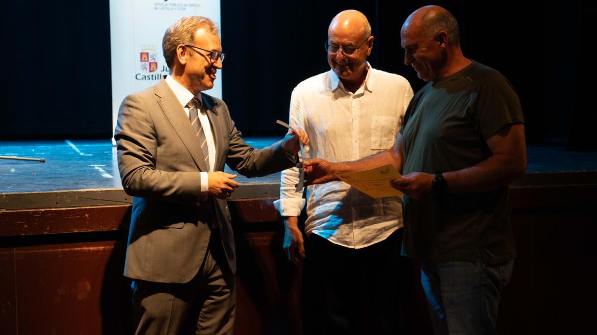 El consejero entrega el certificado a un alumno del taller de empleo, en presencia del alcalde de Andavías, Antonio Iglesias