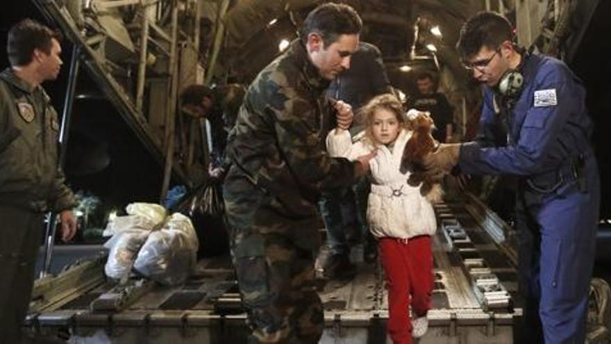 Soldats ajuden a sortir del vaixell de rescat a una nena.