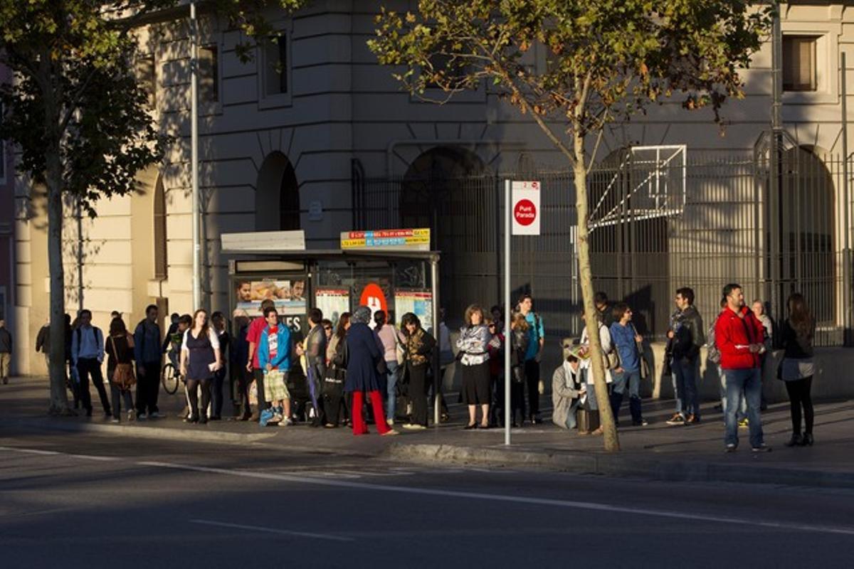 Usuarios de autobuses esperan en una parada, el lunes.