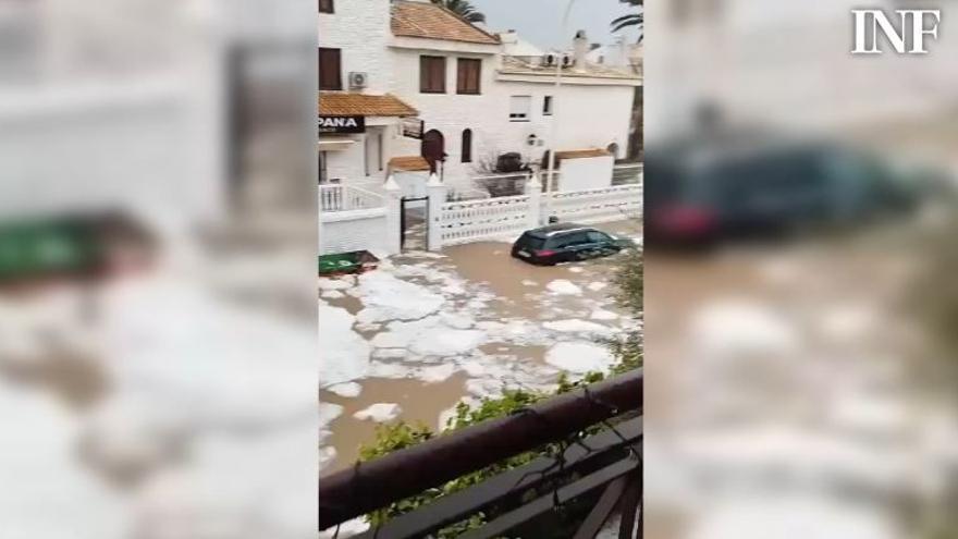 Bloques de hielo de granizo flotando sobre agua acumulada y un muro derribado en Gran Alacant tras el paso de la borrasca Konrad