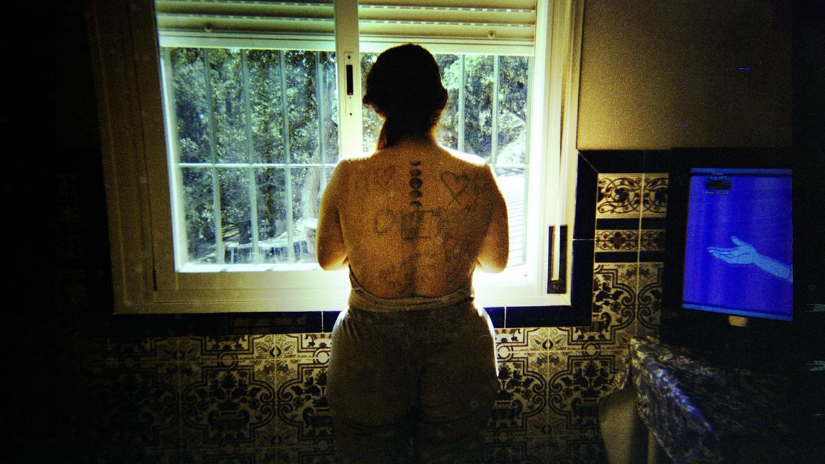 Fotografía de Karen, una de las mujeres participantes en el proyecto, con sus tatuajes y los dibujos que su hijo le hizo en la espalda, y que ella quiso retratar.