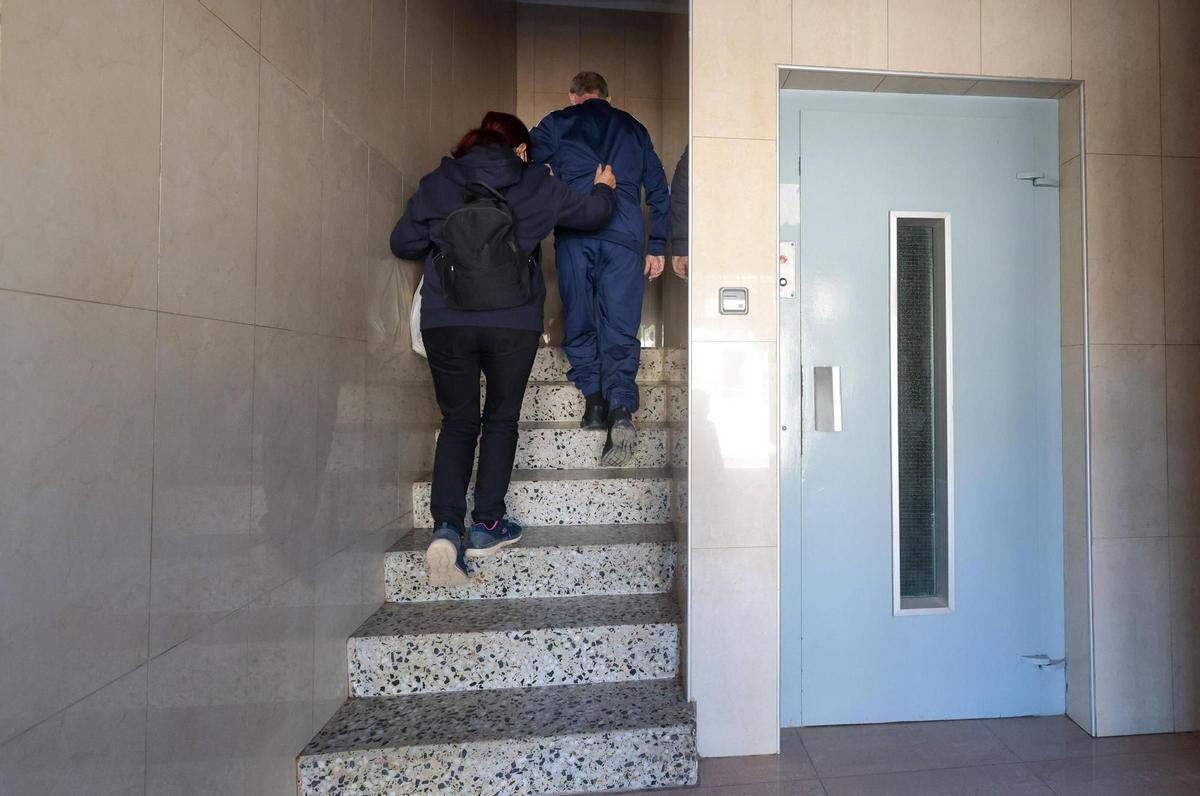 Jose sube las escaleras con la ayuda de su mujer Josefa ante la ausencia de ascensor.