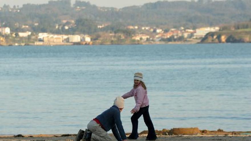 Dos niñas juegan en la playa coruñesa de Oza un día soleado de invierno.