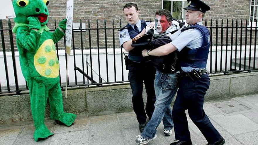 Un ciudadano irlandés es empujado por policias irlandeses delante del Edificio de Gobierno en Dublín, Irlanda, hoy 21 de julio del 2008, durante la llegada del Presidente francés Nicolas Sarkozy. Sarkozy se ha reunido con el Primer Ministro irlandés Brian Cowen para discutir cómo proceder despues de la reciente negativa irlandesa al Tratado de Lisboa.