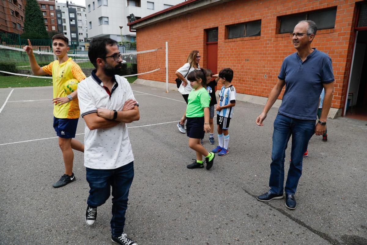 El concejal de Deportes, David García, y el de Educación, Juan Carlos Guerrero, ayer, en el colegio Enrique Alonso, ante un grupo de participantes en una actividad extraescolar de fútbol sala. | Mara Villamuza