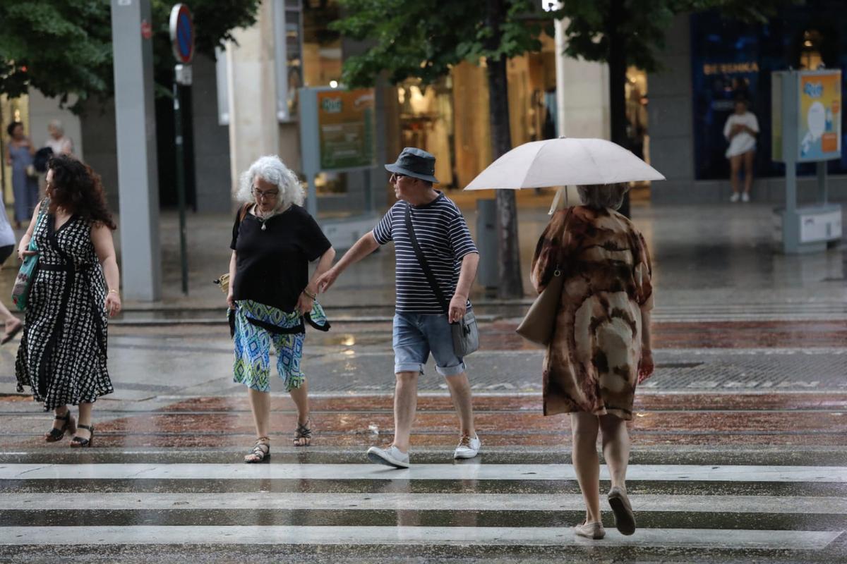 Varias personas pasean bajo la amenaza de lluvia en Zaragoza, en una imagen de archivo