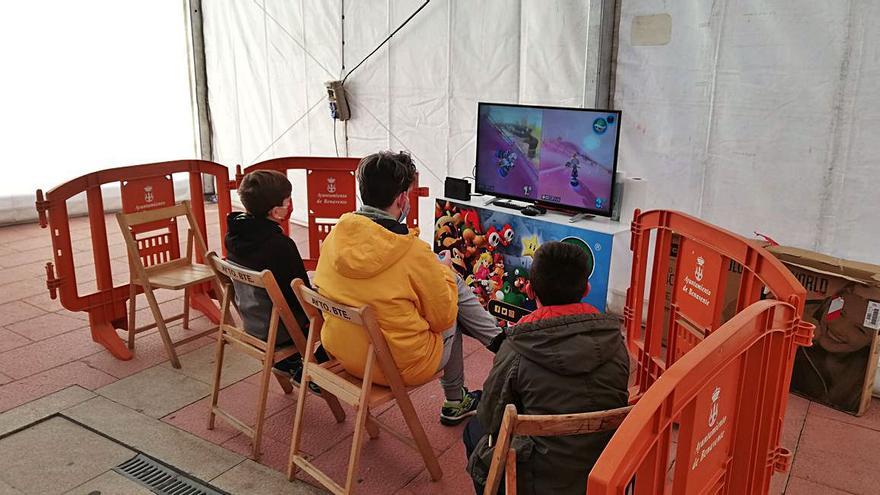 Varios niños disfrutan de un videojuego en una de las cuatro zonas de la carpa. | C. G.R