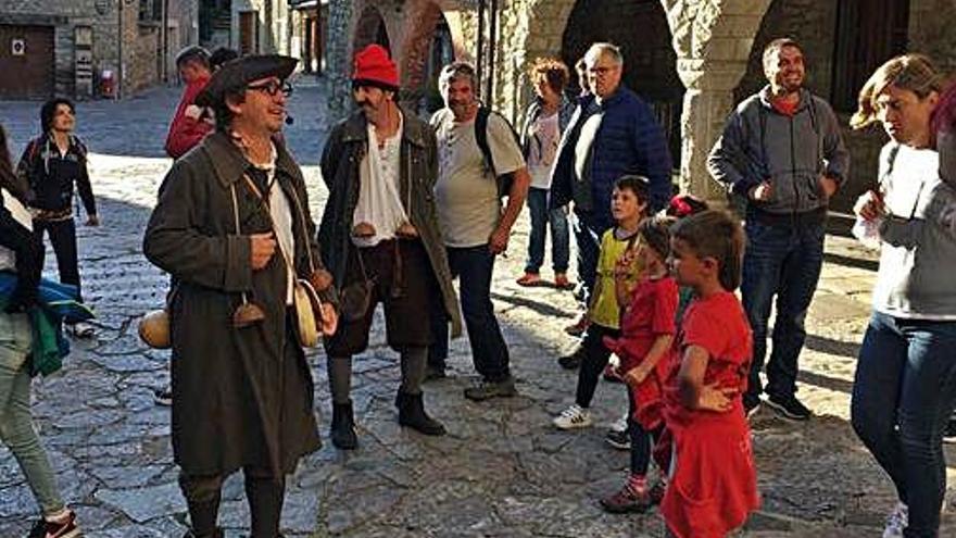 Un grup de visitants envolta els dos actors a la plaça Major de Bellver