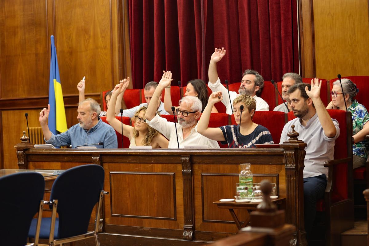 Ediles del equipo de gobierno votando a favor de una de las prórrogas, mientras los de Guanyar mantienen el brazo bajado.