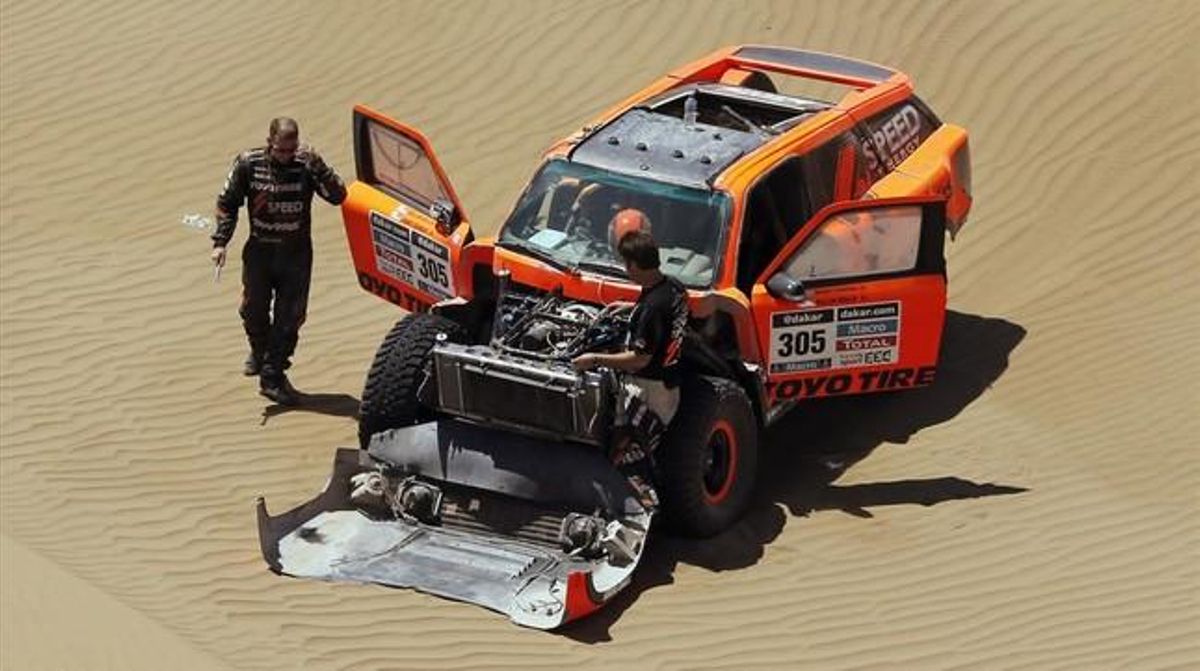Robby Gordon repara el seu Hummer durant la novena etapa.