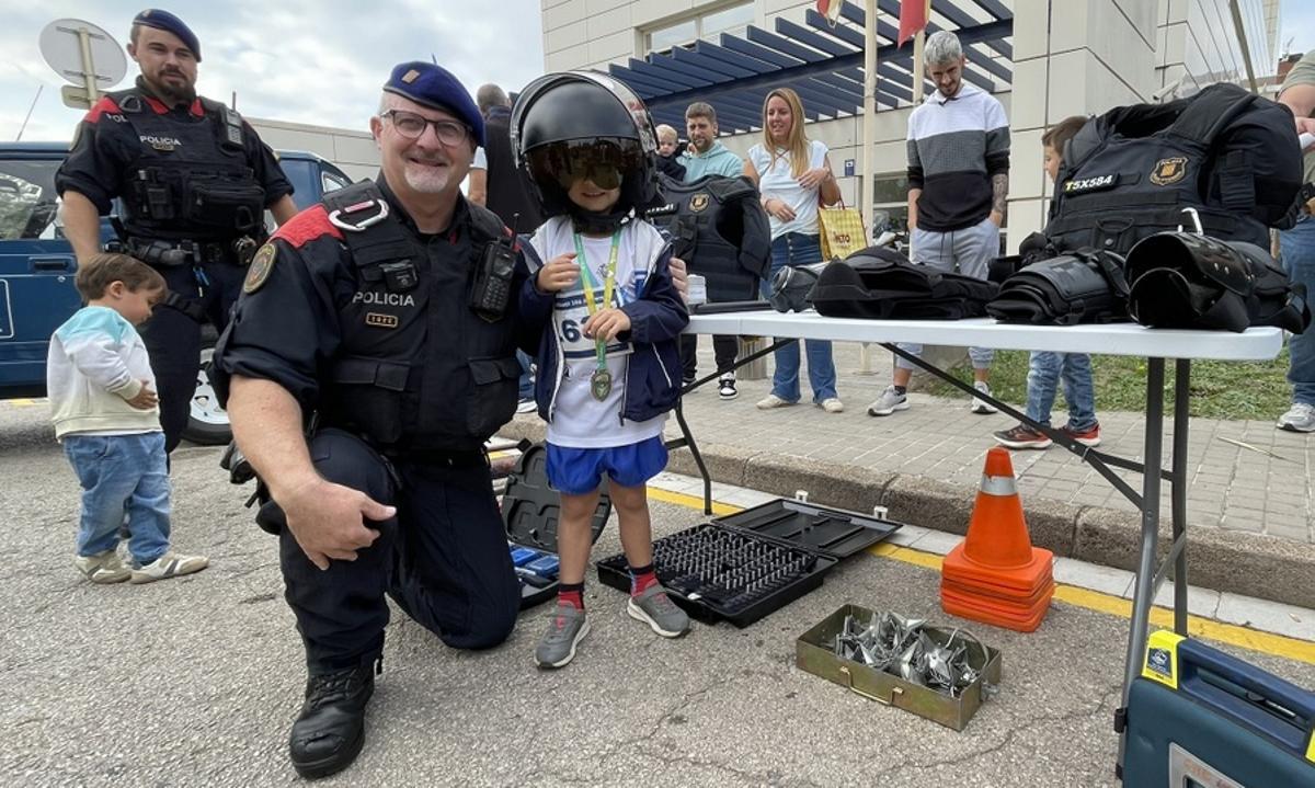 Un nen amb un dels mossos amb la medall del Cros.