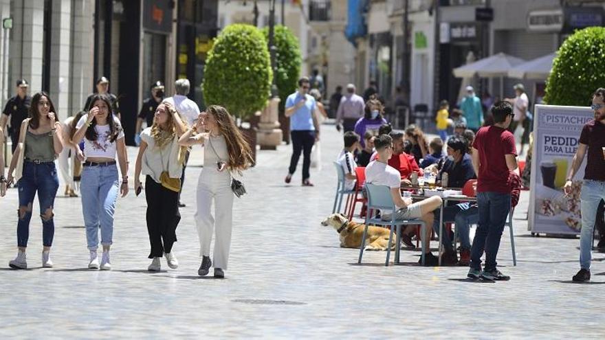 Gente paseando por las calles de Cartagena y terrazas con clientes.