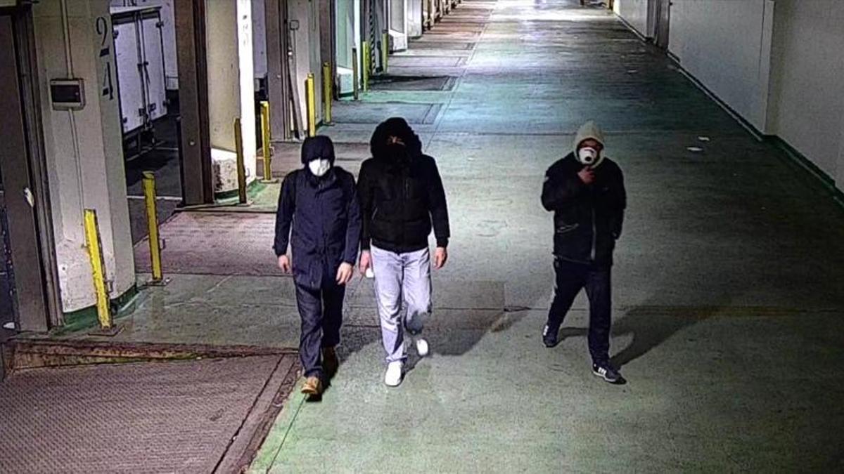 Los tres supuestos sindicalistas, con el rostro tapado, recorriendo instalaciones portuarias la noche del pasado domingo.