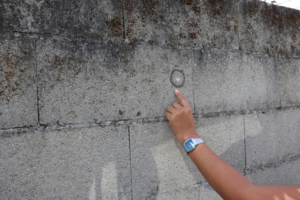 La mujer muestra la marca de otro de los impactos, en este caso en un muro.