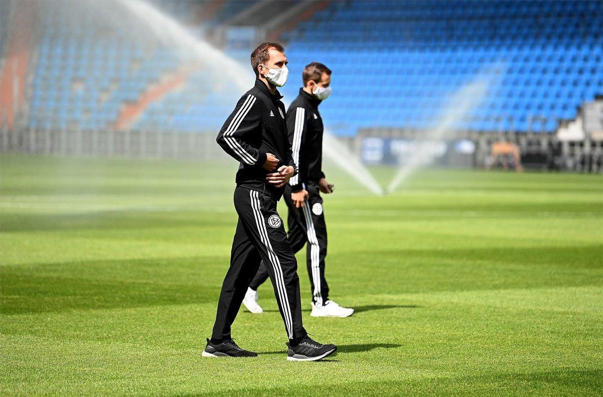 Los colegiados revisan el estado del césped antes del partido con las mascarillas Los colegiados revisan el estado del césped antes del partido con las mascarillas