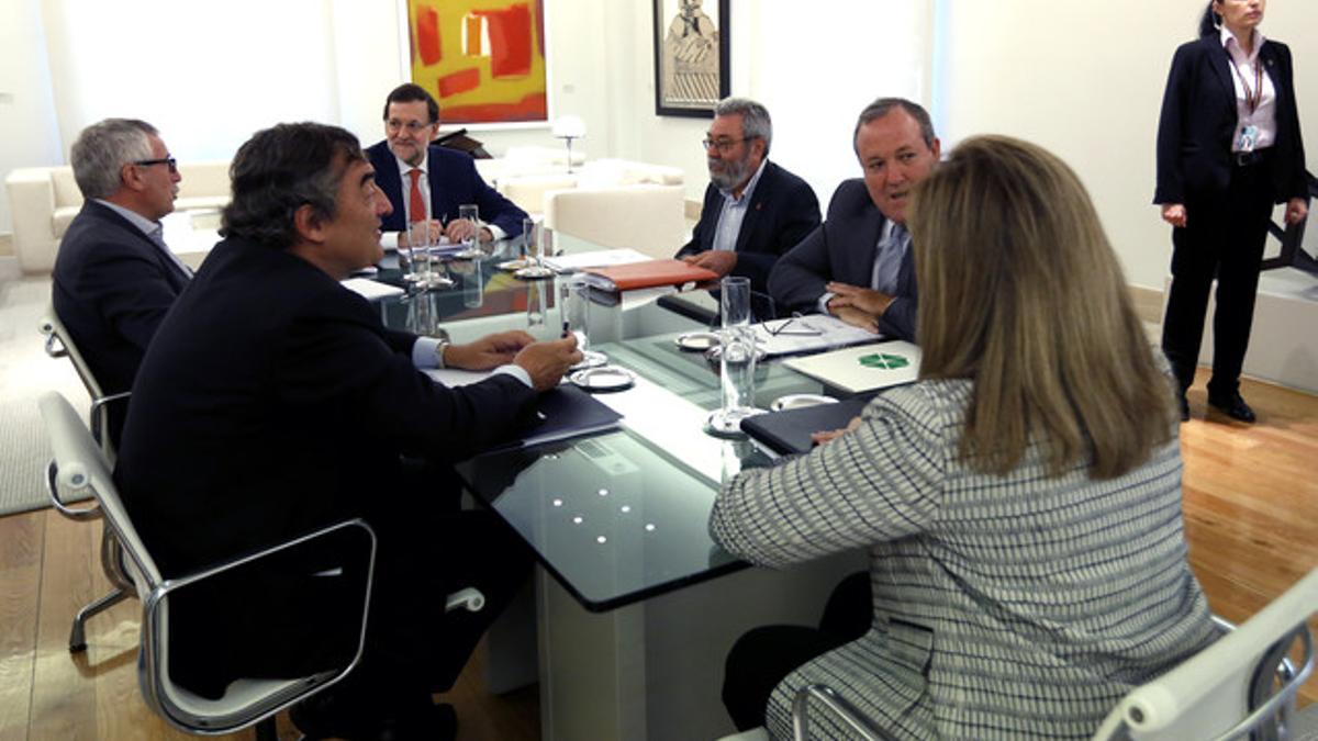 Rajoy y la ministra Fátima Báñez, junto a los representantes de las organizaciones empresariales CEOE y Cepyme y los sindicatos CCOO y UGT, en la Moncloa, este martes.