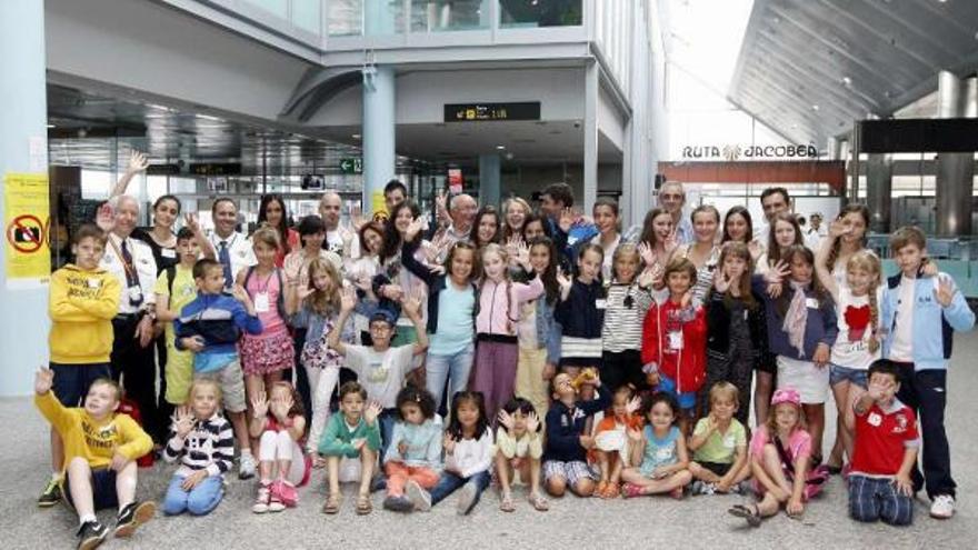 Foto de familia de los niños y sus hermanos de acogida al terminar su visita por las instalaciones del aeropuerto.  // Marta G. Brea