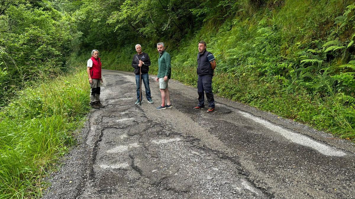 Teresa Iglesias, Guillermo Cots, Pedro Llera y Jorge Muslera junto a uno de los tramos más dañados de la carretera.