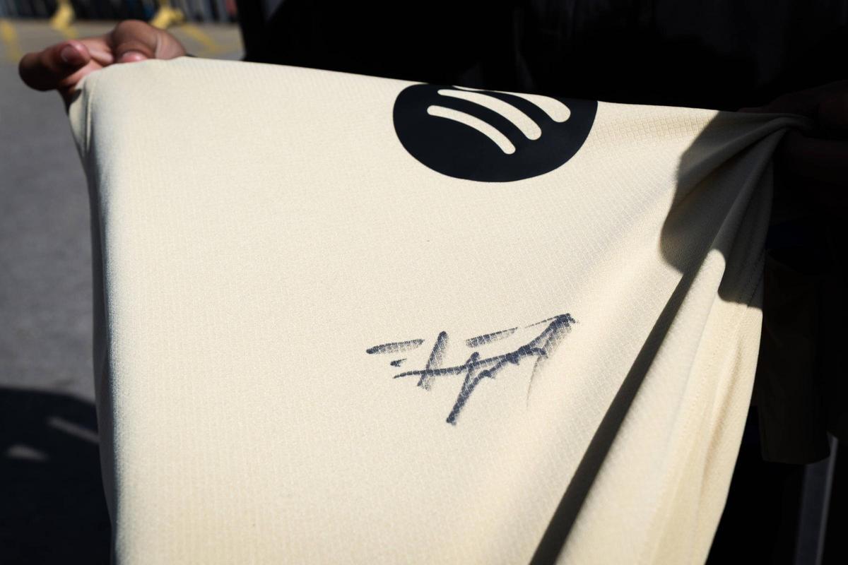 Un aficionado muestra la camiseta firmada por Frankie De Jong.