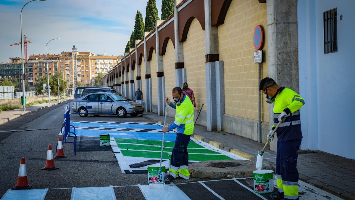 Dos operarios de Badajoz pintan un paso de cebra tras hacer lo mismo con aparcamientos para personas con movilidad reducida.