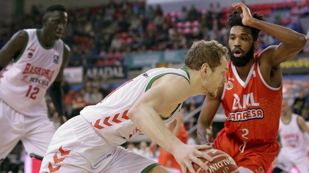 El jugador esloveno del Baskonia Jaka Blazic intenta avanzar ante el escolta estadounidense del ICL Manresa Scott Suggs.