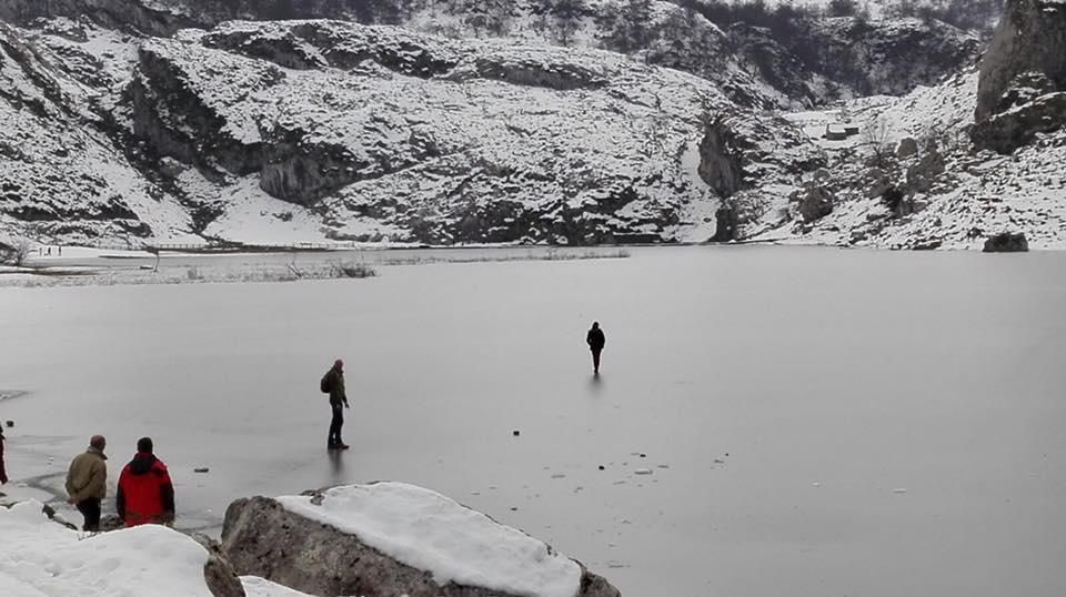 Turistas caminando sobre el lago Ercina