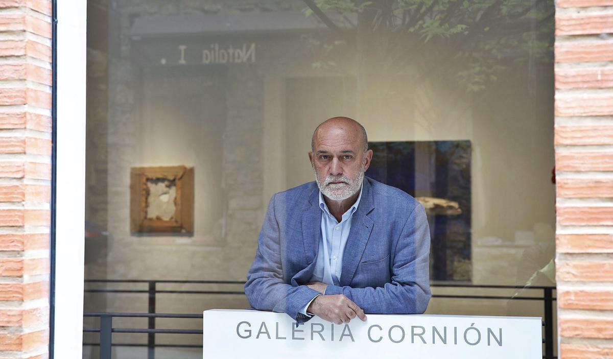 Amador Fernández, asomado al escaparate de su librería-galería.