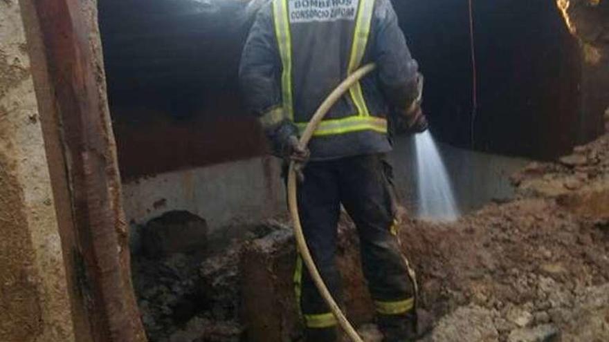 Un bombero termina de sofocar el incendio.