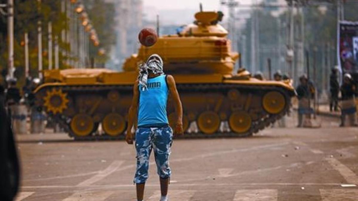 Un simpatizante de Mursi juega al fútbol ante un tanque que protege el palacio presidencial en El Cairo.