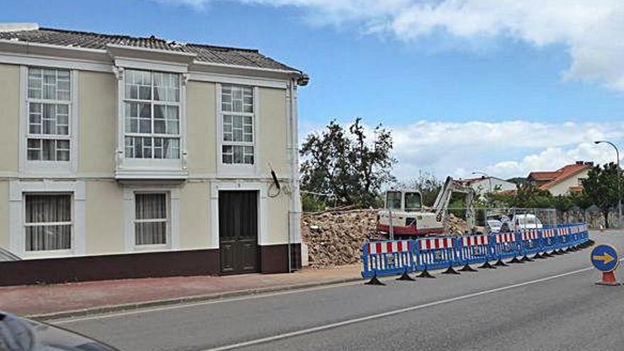 Excavadora tras demoler la vieja unitaria pegada a la vivienda y desvío de tráfico, ayer en Coruxo.