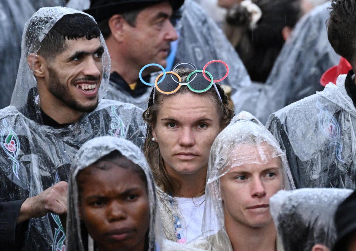 La delegación alemana con ponchos para la lluvia durante el desfile flotante por el río Sena durante la ceremonia de apertura