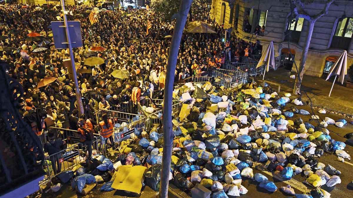 Manifestantes arrojan bolsas de basura cerca de la delegación del Gobierno, en Barcelona.