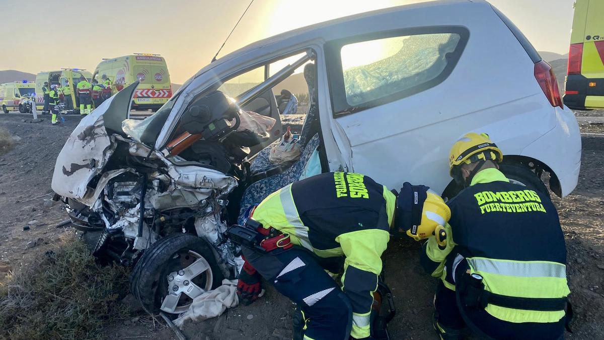 Bomberos de Fuerteventura junto al vehículo en el que falleció una mujer este domingo.