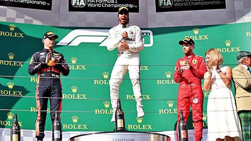 Hamilton celebra su victoria en el centro de la imagen; a su izquierda, Max Verstappen, segundo; y a su derecha, Sebastian Vettel, tercero.