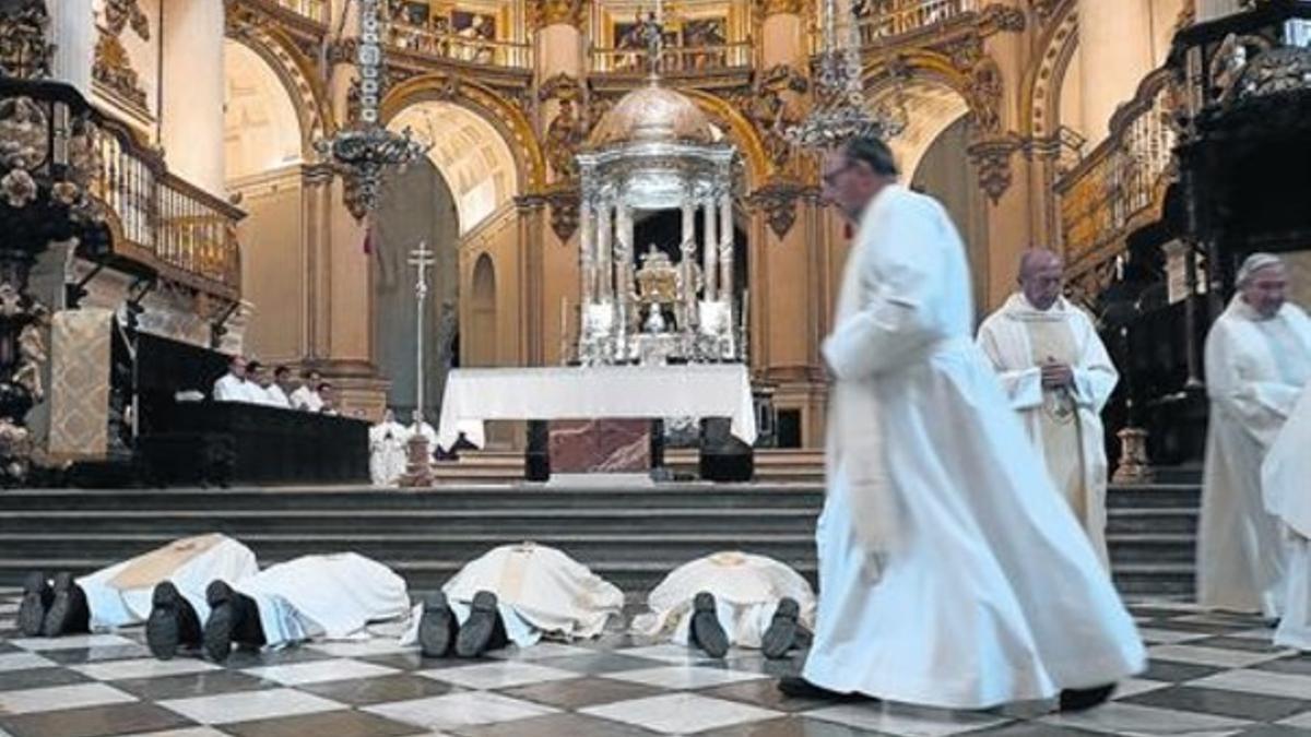 Decúbito prono 8 El arzobispo Francisco Javier Martínez, postrado ante el altar mayor de la catedral de Granada, ayer, junto a otros oficiantes.