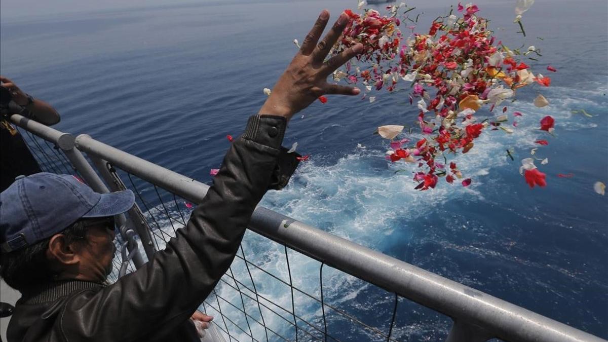 Un familiar de una de las víctimas del accidente del avión de Lion Air lanza flores en las proximidades del lugar donde se produjo el siniestro, en Indonesia.