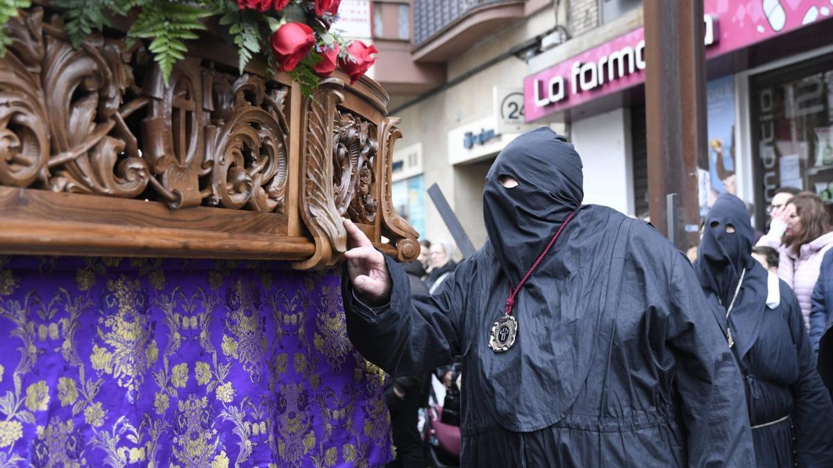 Un responsable de paso transmite las órdenes a la carga en un desfile de Jesús Nazareno.